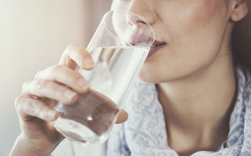 A woman drinking a glass of water