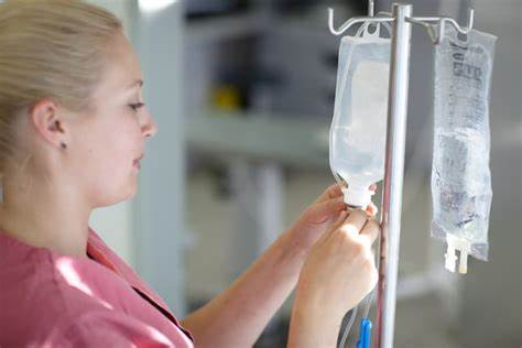 Nurse adjusting an IV bag