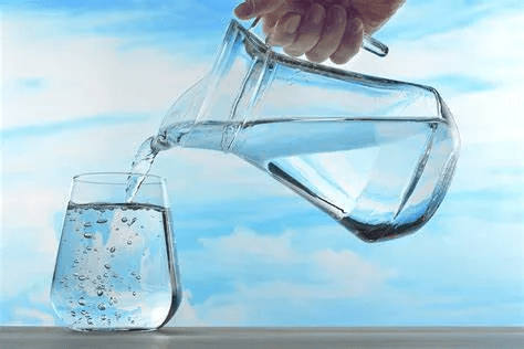 Pouring water from a jug into a glass