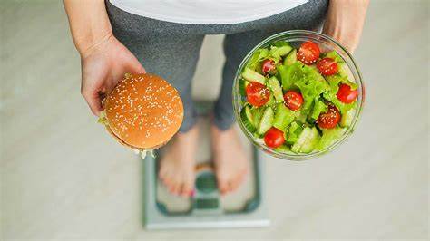 Women weighing herself holding a burger and a healthy diet 